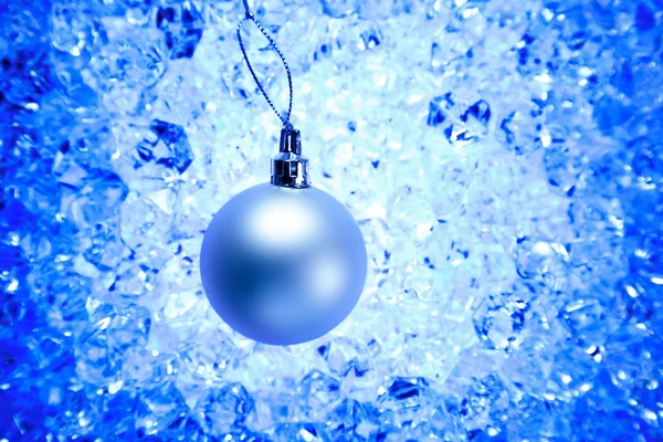 Weihnachtskugel auf blauem Wintereis — Stockfoto