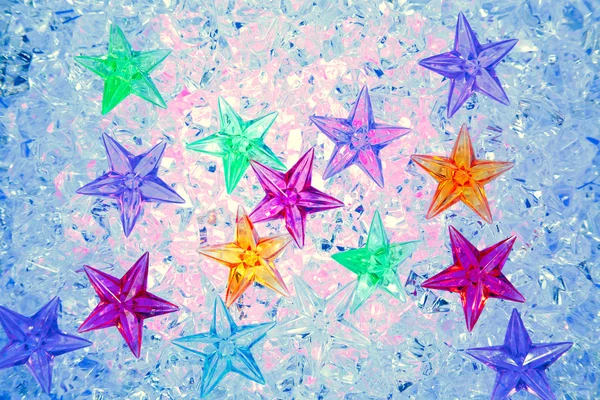 青い氷の上でクリスマスのカラフルな星 — ストック写真