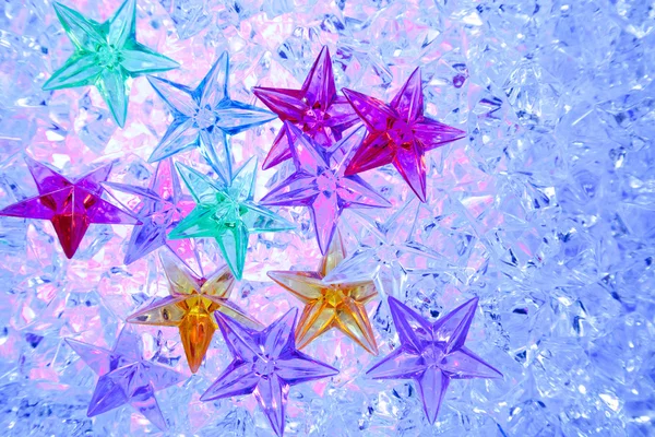 Weihnachten bunte Sterne auf blauem Eis — Stockfoto