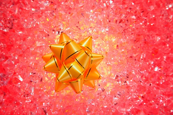 Presente de Natal fita dourada no gelo vermelho — Fotografia de Stock