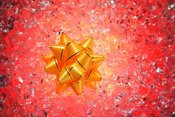 Рождественский подарок золотая лента на красном льду — стоковое фото