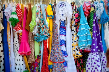 Colorful gipsy dresses in rack hanged in Spain clipart