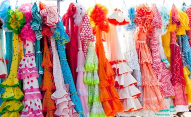 Colorful gipsy dresses in rack hanged in Spain clipart