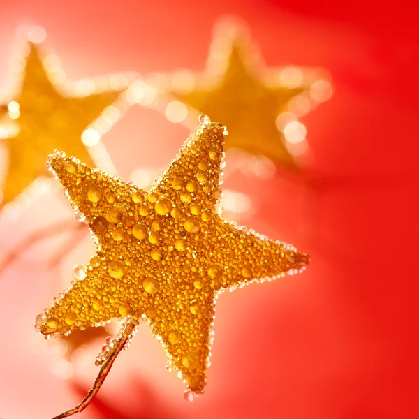 Vánoční zlaté kapky hvězda v červené barvě — Stock fotografie