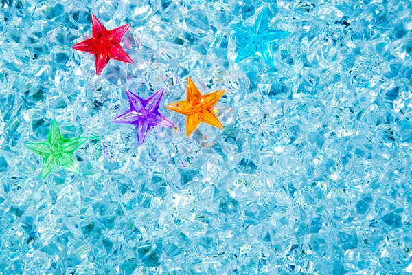 Natal estrelas de vidro coloridas no gelo azul frio — Fotografia de Stock