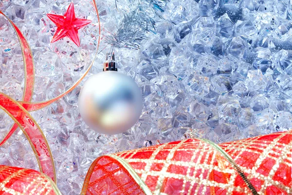 Zilveren Kerstbal en rood lint op ijs — Stockfoto
