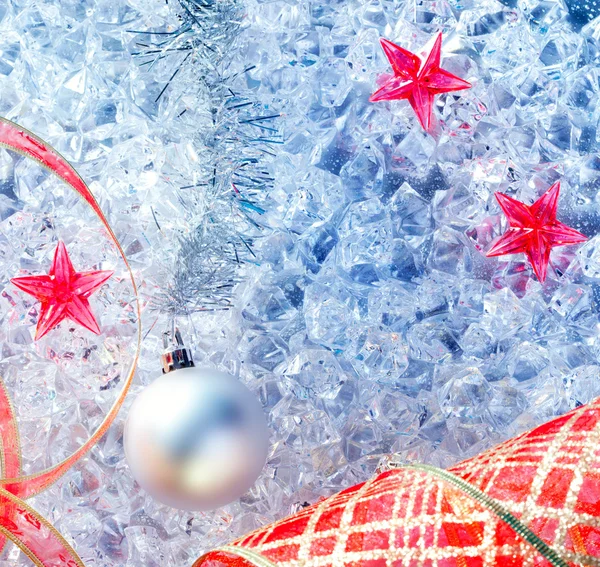 Zilveren Kerstbal en rood lint op ijs — Stockfoto