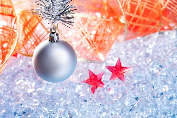 Christmas silver bauble and red ribbon on ice — Stock Photo, Image