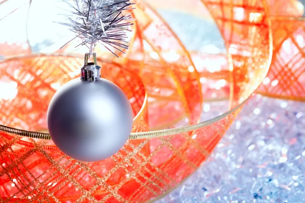 Zilveren Kerstbal met rood lint op ijs — Stockfoto