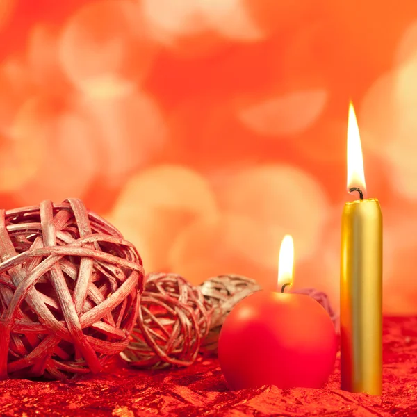 Christmas candles with dried baubles on red — Stock Photo, Image
