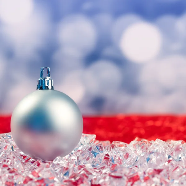 Christmas silver bauble on ice cubes — Stock Photo, Image