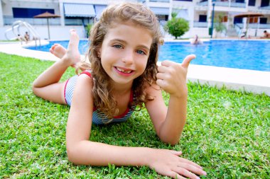 Children girl lying on pool grass in summer clipart