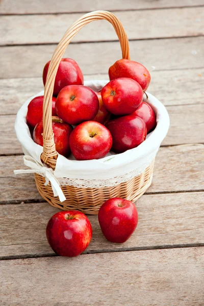 Mandje van rode appels op houten vloer — Stockfoto