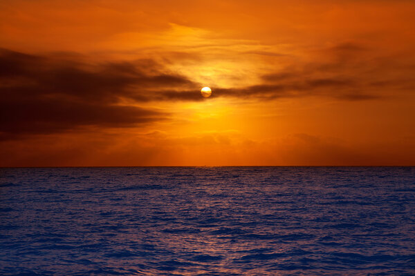 Golden sunrise with sun and clouds over blue Mediterranean sea