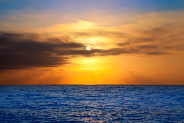 Golden sunrise with sun and clouds over sea — ストック写真