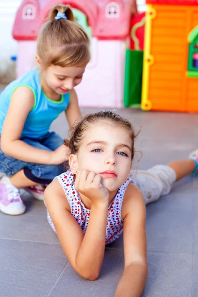 Piękne małe dziewczynki leżącego na podłodze plac zabaw dla dzieci — Zdjęcie stockowe