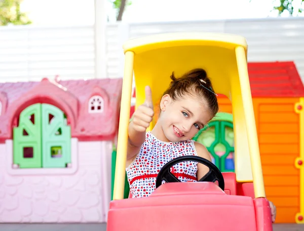 Barn tjej kör en leksaksbil med ok gest — Stockfoto