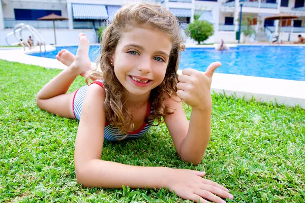 Children girl lying on pool grass in summer — Stock Photo, Image