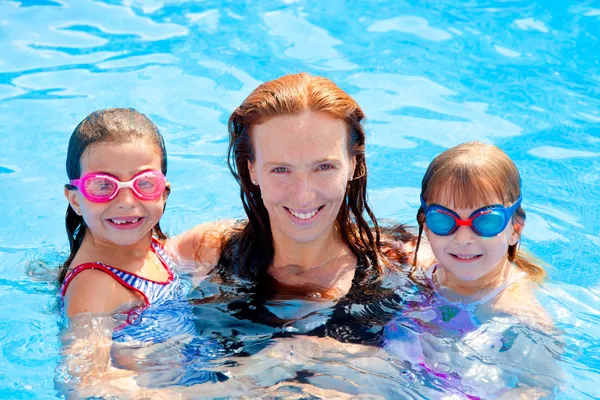 Дочери и мать семьи плавают в бассейне — стоковое фото