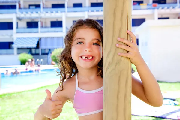 Indented kid girl ok gesture in pool garden — Stock Photo, Image