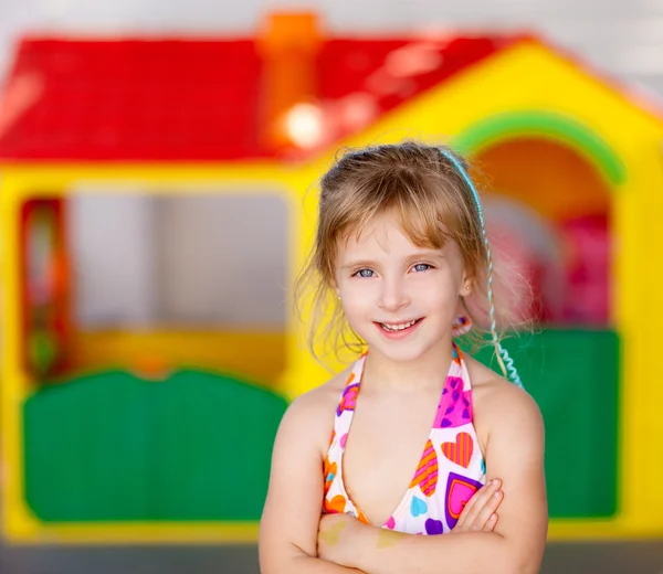 Loira criança menina cruzou os braços em casa de brinquedo — Fotografia de Stock