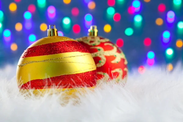 Kerstballen op witte vacht en verlichting — Stockfoto