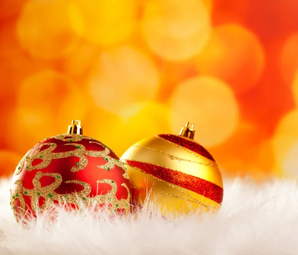Julgranskulor på vit päls och lampor — Stockfoto