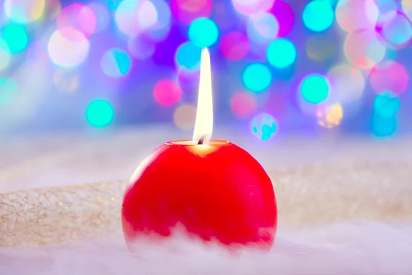 Christmas red candle on fur and colorful light — Stock Photo, Image