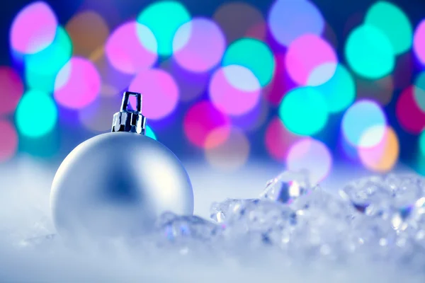 Christmas silver bauble in blurred lights — Stock Photo, Image