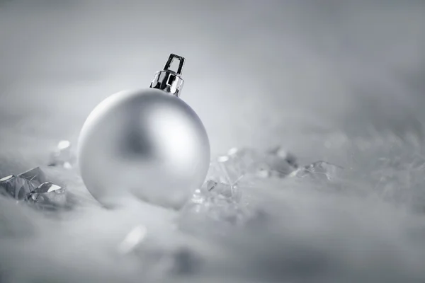 Рождественская серебряная безделушка на снегу и льду — стоковое фото