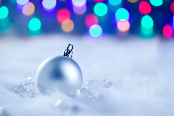 Natal bugiganga de prata em luzes embaçadas — Fotografia de Stock