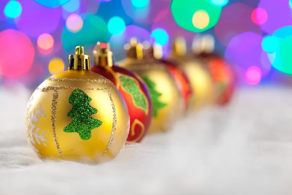 Weihnachten goldene rote Kugeln in einer Reihe mit Lichtern — Stockfoto