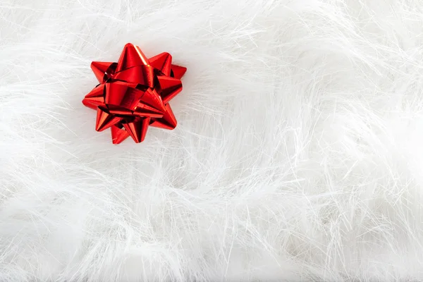 Kerstmis rood lint kijkt over witte vacht — Stockfoto