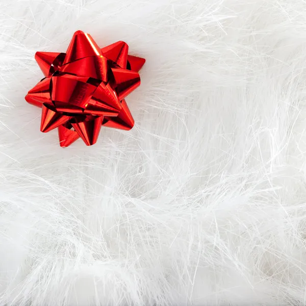 Κόκκινη κορδέλα Χριστούγεννα κοιτάξουν πέρα από το άσπρο fur — Stockfoto