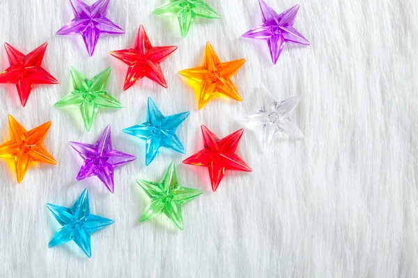 Barevné skleněné vánoční hvězdy nad bílou srstí — Stock fotografie