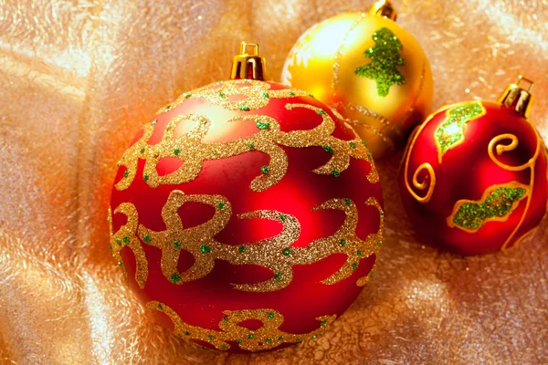 Röda julgranskulor på gyllene tyg — Stockfoto