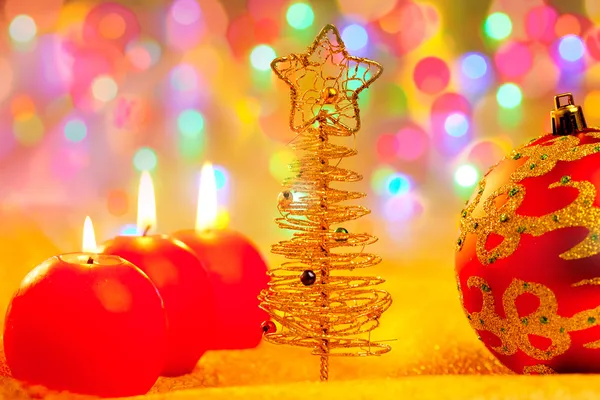 Natal dourado vermelho bugigangas em luzes embaçadas — Fotografia de Stock