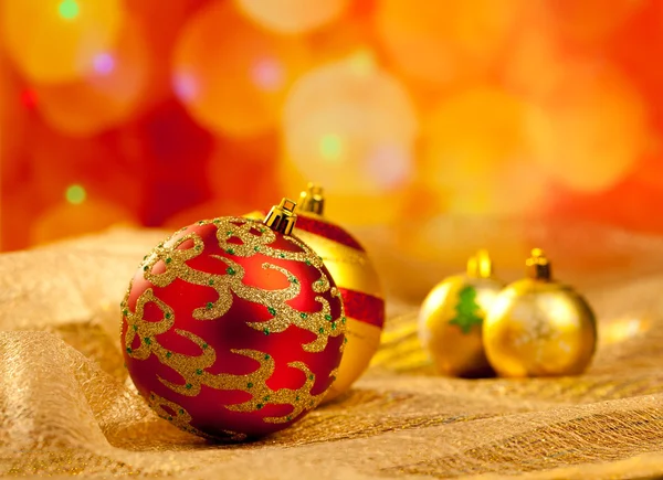 Guld och röda julgranskulor i oskärpa lampor — Stockfoto