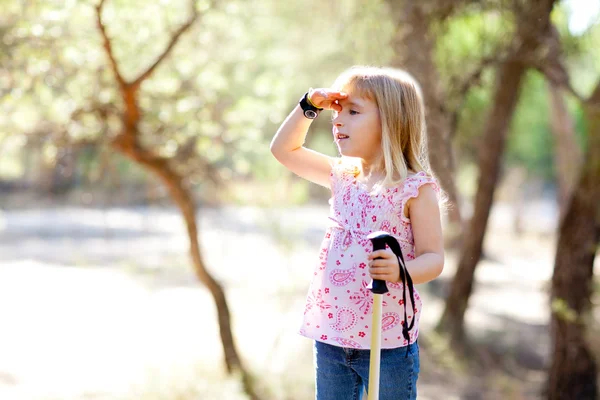 Hiking kid girl searching hand in head in forest — Stock Photo, Image