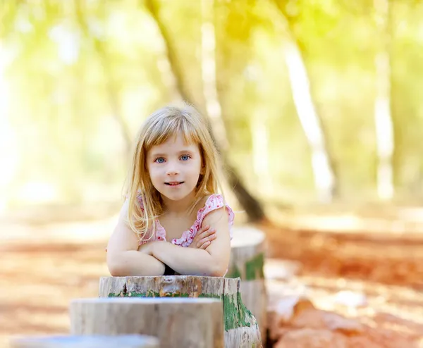 Παιδί ξανθό κορίτσι στο δάσος κορμό δέντρου — Φωτογραφία Αρχείου