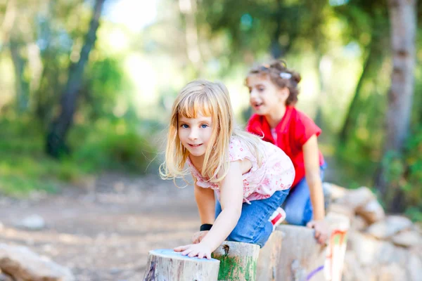Dítě dívky na kmeny stromů v lese přírody — Stock fotografie