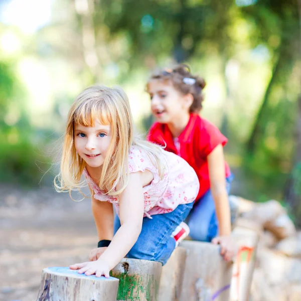 Garotas brincando em troncos na natureza da floresta — Fotografia de Stock