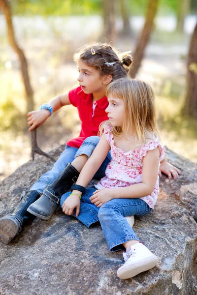 林の岩で遊んで女の子を子供の友人 — ストック写真