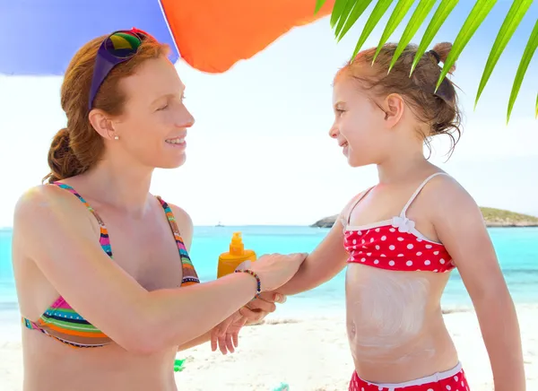 Dotter och mor i beach med solskyddsmedel — Stockfoto