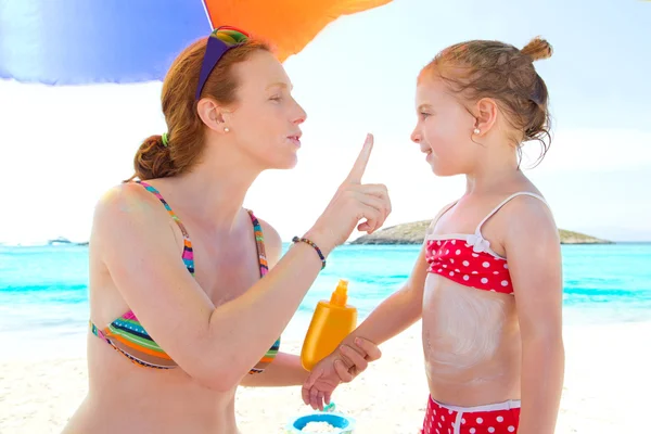 Tochter und Mutter am Strand mit Sonnencreme — Stockfoto