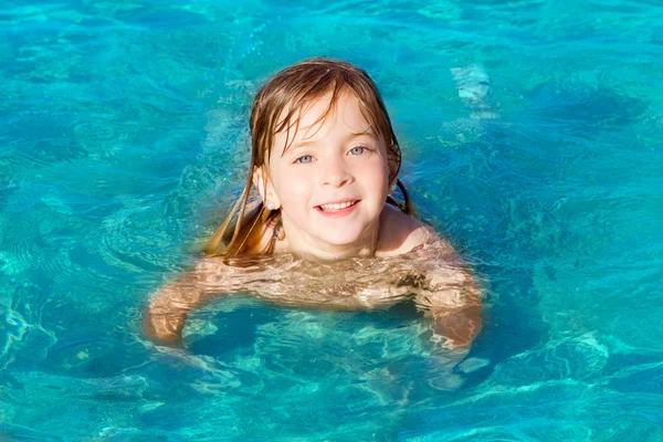 Petite fille blonde nageant sur une plage turquoise — Photo