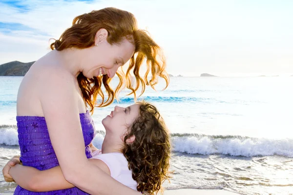 Dochter en moeder knuffel op het strand ibiza — Stockfoto