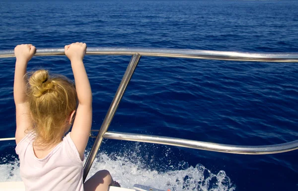Blonde weinig meisje achteraanzicht zeilen in boot — Stockfoto