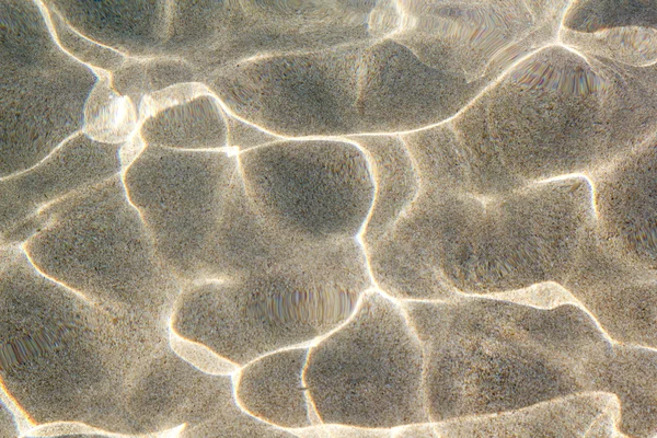 Strand zand onder rimpel van water golven — Stockfoto