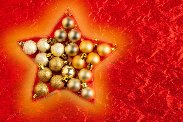 Christmas baubles in star shape on red — Stock Photo, Image